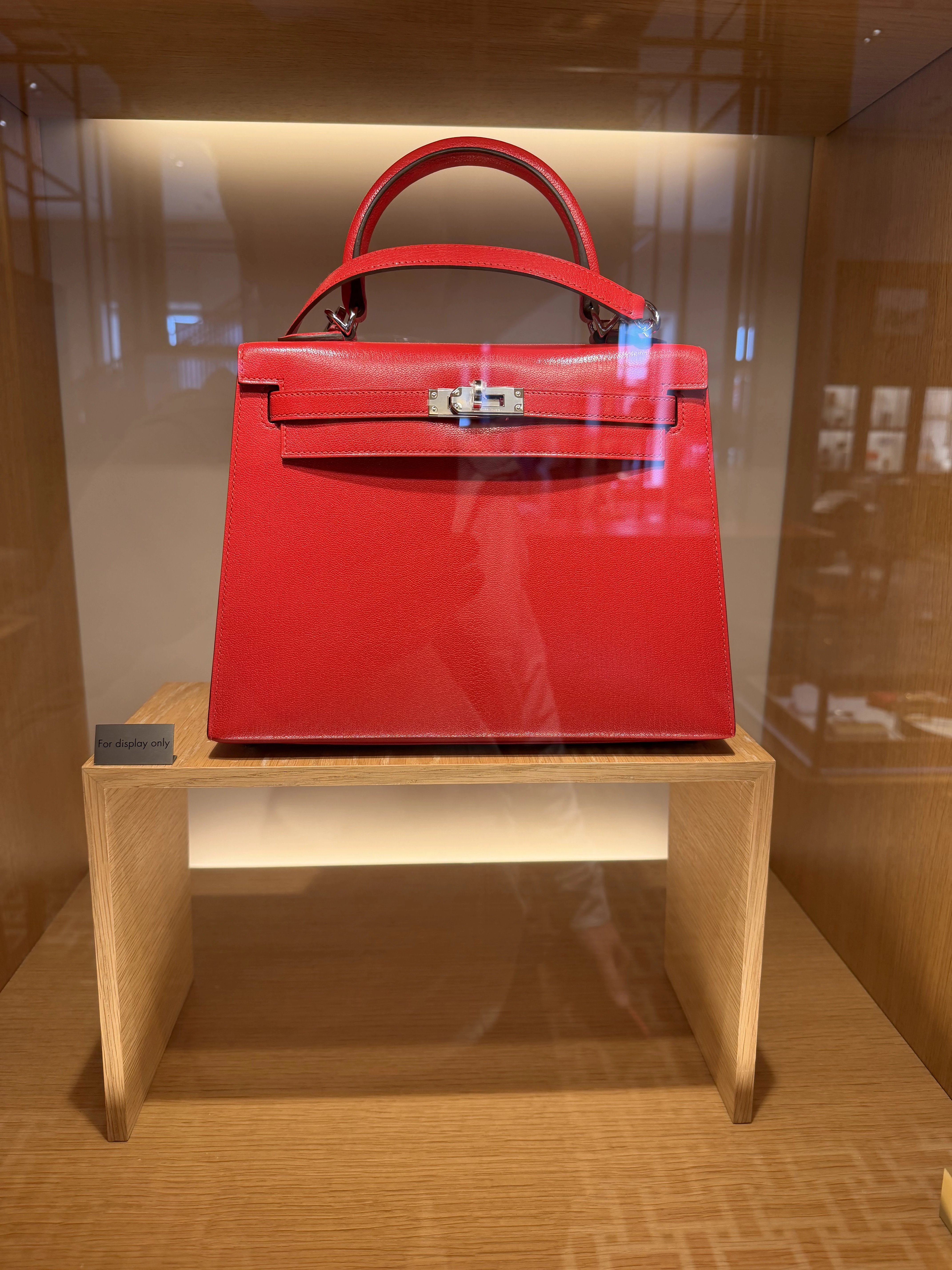 サンフランシスコのブティックでガラスケースに展示された赤いエルメス ミニケリー セリエ